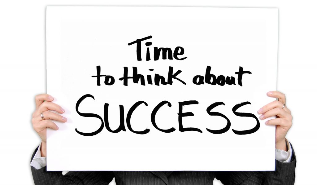 Person holding up sign that says time to think about success